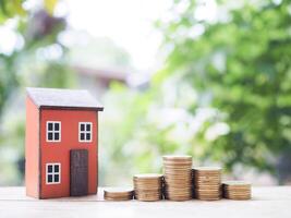 Miniature house and stack of coins. The concept of saving money for house, Property investment, House mortgage, Real estate photo