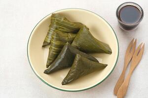 Lupis or Lopis, a traditional Indonesian food made from sticky rice and wrapped in banana leaves. photo