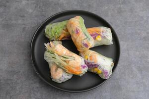 Vegetable spring roll, fresh roll salad made from mix vegetables with shrimp. Served in plate with caesar sauce dressing photo