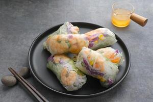 Vegetable spring roll, fresh roll salad made from mix vegetables with shrimp. Served in plate with caesar sauce dressing photo