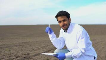 Indian scientist checks the quality of the soil for control soil quality before seed plant. Future agriculture concept. Smart farming, using modern technologies in agriculture video