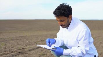 Indian scientist checks the quality of the soil for control soil quality before seed plant. Future agriculture concept. Smart farming, using modern technologies in agriculture video