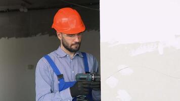 Professional drywall worker or plasterer using cordless electric screwdriver to fix the plasterboard sheets to the metal profiles to build the new wall video