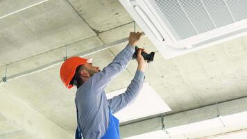 Technician worker installs air conditioning system at office video