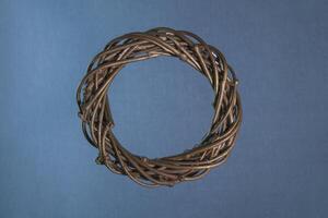 Christmas wreath on a blue-gray background, made of twigs with gilding. Square format. Close-up, texture. photo