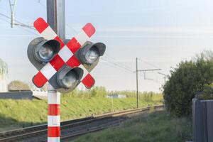 Railway signal light - semaphore and barrier. Railway crossing. Warning road sign about the proximity of a railway crossing. photo