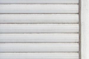 old white external blinds on hard plastic windows. fragment of adhesion to the wall photo