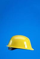 Hard hat isolated on blue vertical background with copy space, 3d render. photo