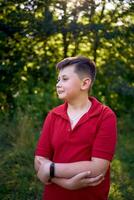 portrait of a preteen boy in a red t-shirt in the park photo