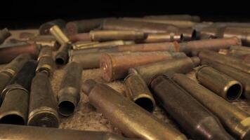A close-up view of a collection of spent brass casings on a Burlap Surface. The casings are of various lengths and have been used, leaving them with a dull, worn appearance. video