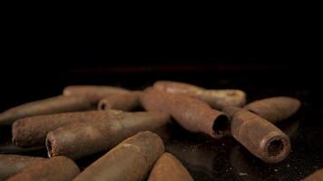 Close-up of old rusty bullets. Bullets lie chaotically on a black surface. video