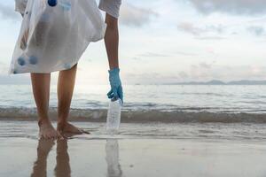 Save water. Volunteer pick up trash garbage at the beach and plastic bottles are difficult decompose prevent harm aquatic life. Earth, Environment, Greening planet, reduce global warming, Save world photo
