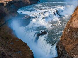 Aerial View of Majestic Waterfall Cascading Down Cliff in Iceland photo