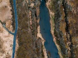 Aerial View of a Deep Blue River Winding Through Rocky Icelandic Landscape photo