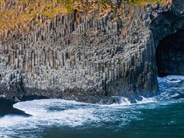 Hexagonal Basalt Columns on Icelandic Coast with Ocean Waves Crashing photo