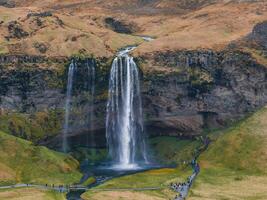 Aerial View of Seljalandsfoss Waterfall Cascading Down a Cliff in Iceland photo
