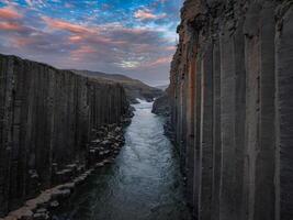 Aerial View of River Flowing Through Narrow Canyon with Dramatic Sky photo