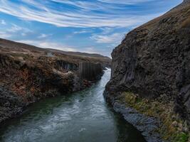 Aerial View of Turbulent River Flowing Through Steep Canyon in Iceland photo