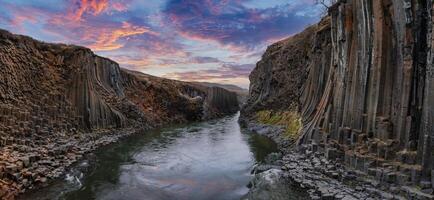 Scenic Canyon with Basalt Columns and Reflective River at Sunset in Iceland photo