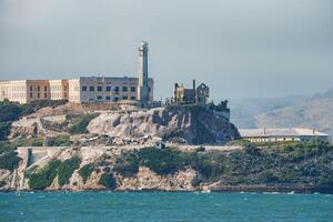 Distant view of Alcatraz Island in San Francisco Bay, USA, known for the infamous former Alcatraz Federal Penitentiary. Rocky terrain, lighthouse, and maritime activities. photo