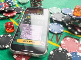Online poker concept. Smartphone and poker chips on a green background. Poker online banner. Copy space. Vignette. Place for text. Gambling. Background photo