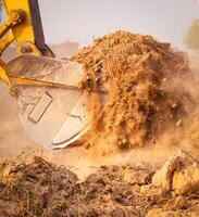 Close-up of excavator at construction site. Backhoe digging soil for earthwork and construction business. Excavating machine at work. Heavy machinery for earth moving and construction site development photo