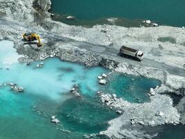 Open pit mine industry. Limestone quarry with backhoe and truck in operation. Heavy machinery in mining industry and construction material supply. Landscape of resource extraction in a industrial site photo