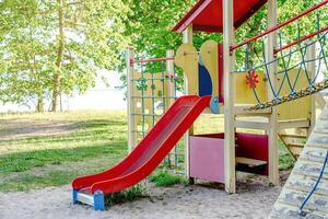 Children's playground with a red slide, perfect for outdoor recreation photo