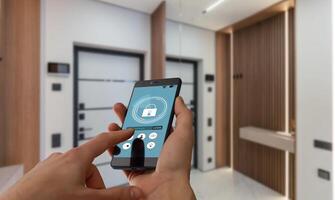 Young woman holding smart phone with launched security application at home. Concept of controlling and managing home security from a mobile device photo