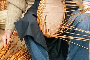 selective focus, artisan's hands making a wicker basket, close-up view photo
