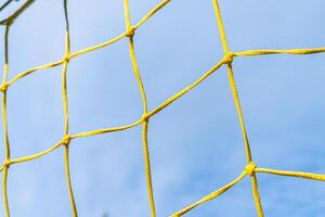 net of a yellow soccer goal with blue sky in the background photo