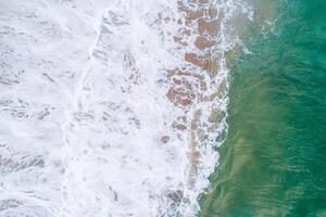 Aerial view from drone of sandy beach and ocean with waves photo