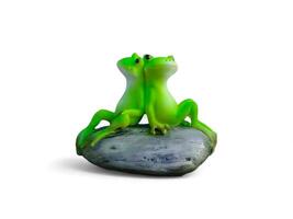 Miniature decoration of two frogs sitting on a rock on a white background photo