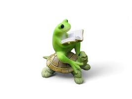 Decorated miniature frog sitting on a turtle and reading a book on a white background photo