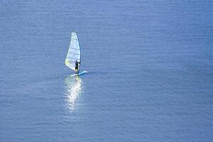 View on a windsurfer with reflection in the water photo