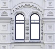 Close up view on a facade of white ancient building with two-part isolated arched windows photo