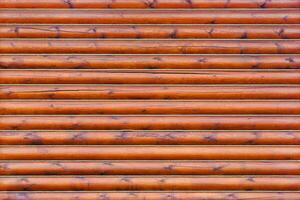 Brown wooden wall from horizontal logs as texture, background photo