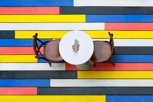 Top view on a round table and chairs on a multi-colored wooden floor in cafe photo
