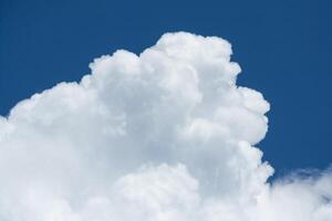 View on a fragment of white cumulus fluffy clouds in blue sky photo