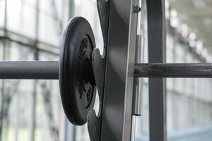 Close up view on a barbell with a pancake on the rack in the gym photo