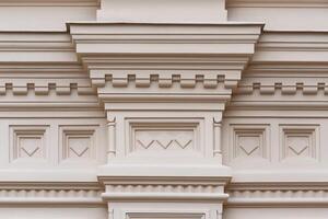 Fragment of the relief frieze with geometric pattern on the wall of beige stone ancient building photo