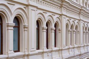 Perspective view on a facade of ancient stone building with decorative ornaments and windows photo