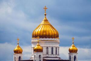 Close up view on a gilded domes of Cathedral of Christ the Savior in Moscow Russia on a background of dramatic cloudy sky photo