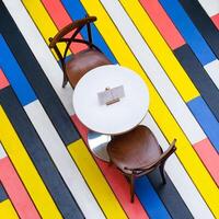 Top view on a round table and chairs on a multi-colored wooden floor in cafe photo