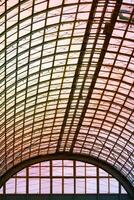 View to hemispherical ceiling of glass and metal in modern building on a background of orange sunlight photo