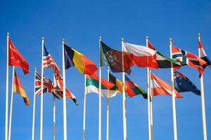 Rows of a flags of different countries of the world a background of clear blue sky photo