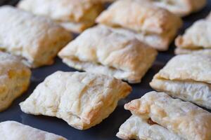Close up view of a freshly baked pies made of puff pastry on a baking sheet photo