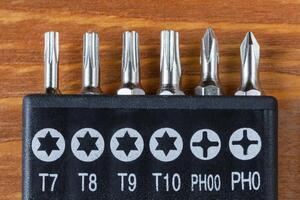 Set of heads for screwdriver bits on a wooden table photo