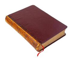 Perspective view of a old closed brown book with red bookmark isolated on a white background photo