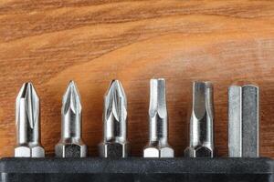 A set of tools collection from heads for screwdriver bits on a wooden table with copy space photo